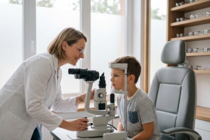 Opticien spécialiste de la vue examinant les yeux d'un enfant dans un cabinet moderne à Entraigues